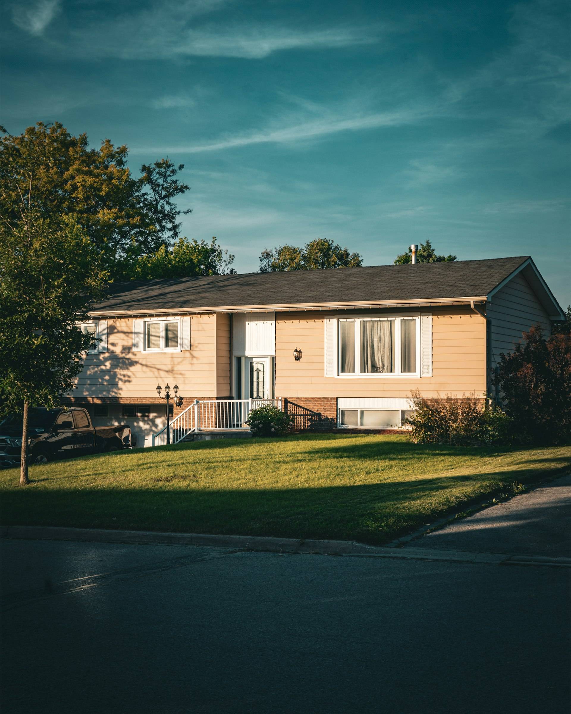A Canadian split-level suburban house at dusk with a pickup truck in the driveway