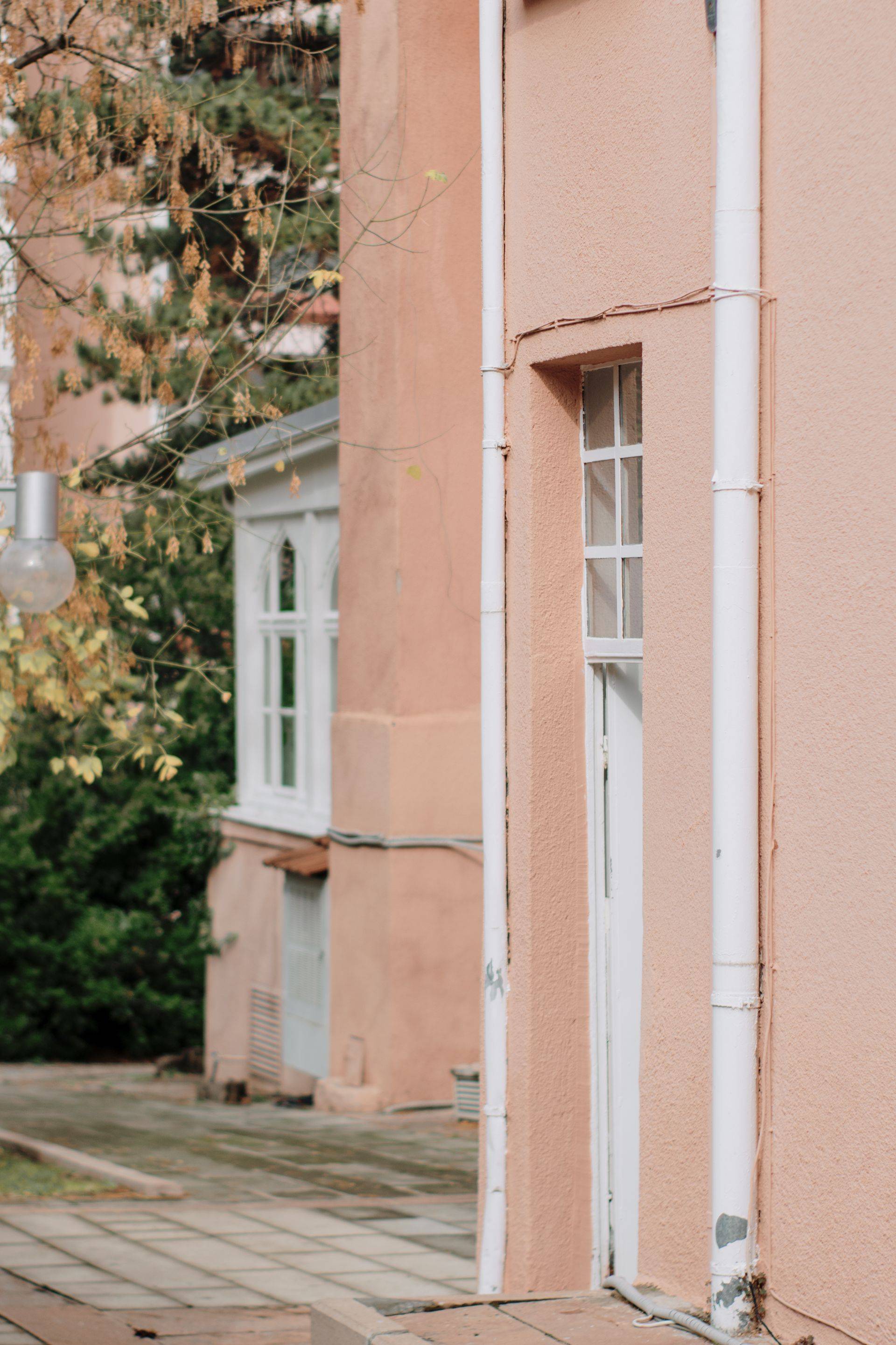 Downpipes running down the corner of a stucco building exterior