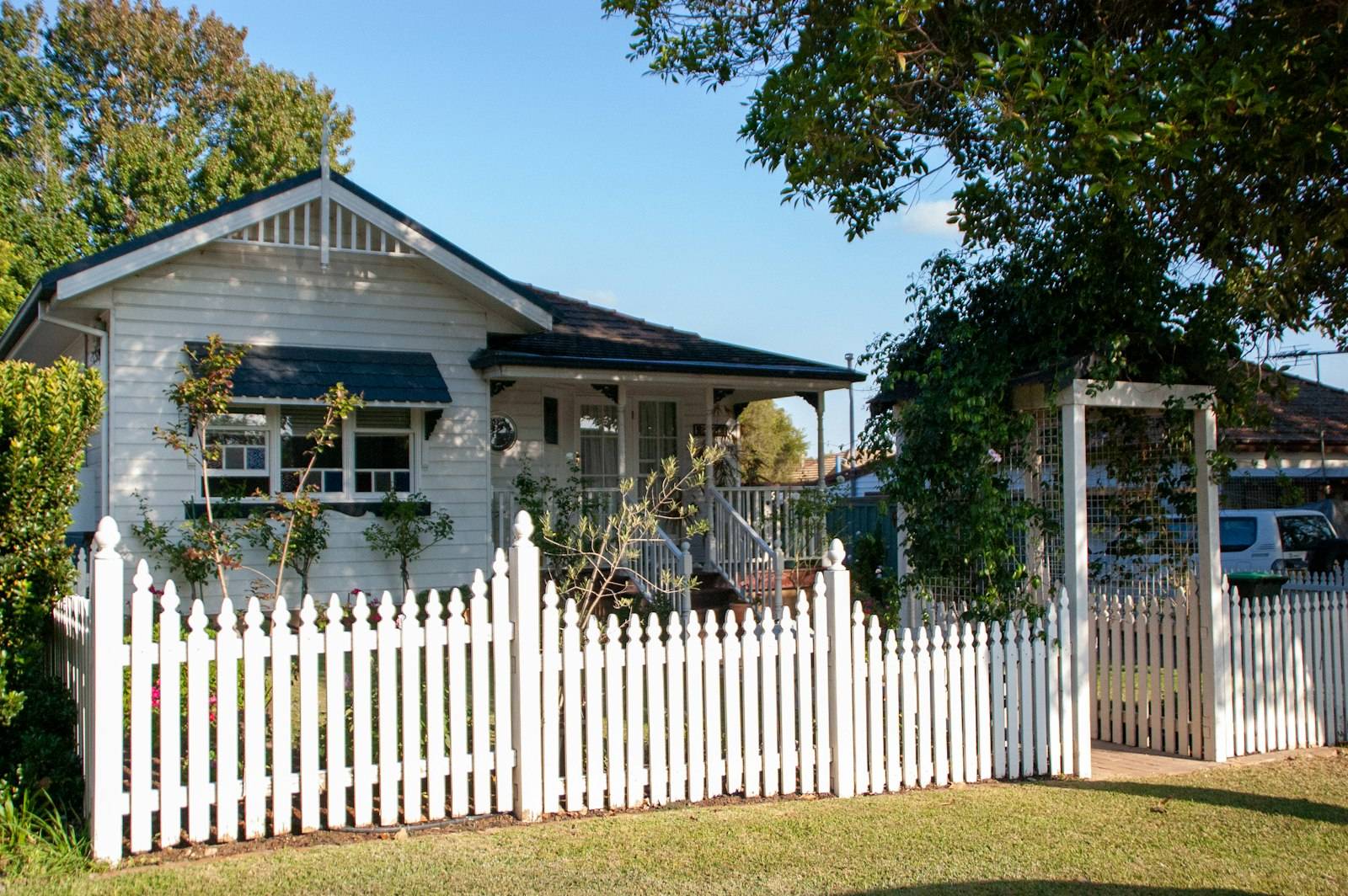 A weatherboard cottage with a white picket fence in Sydney